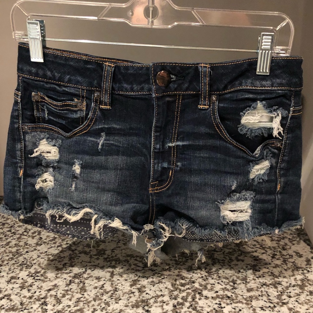 Dark wash distressed shorts with patterned pockets
